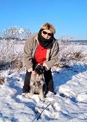 Frau mit Hund in Winterlandschaft